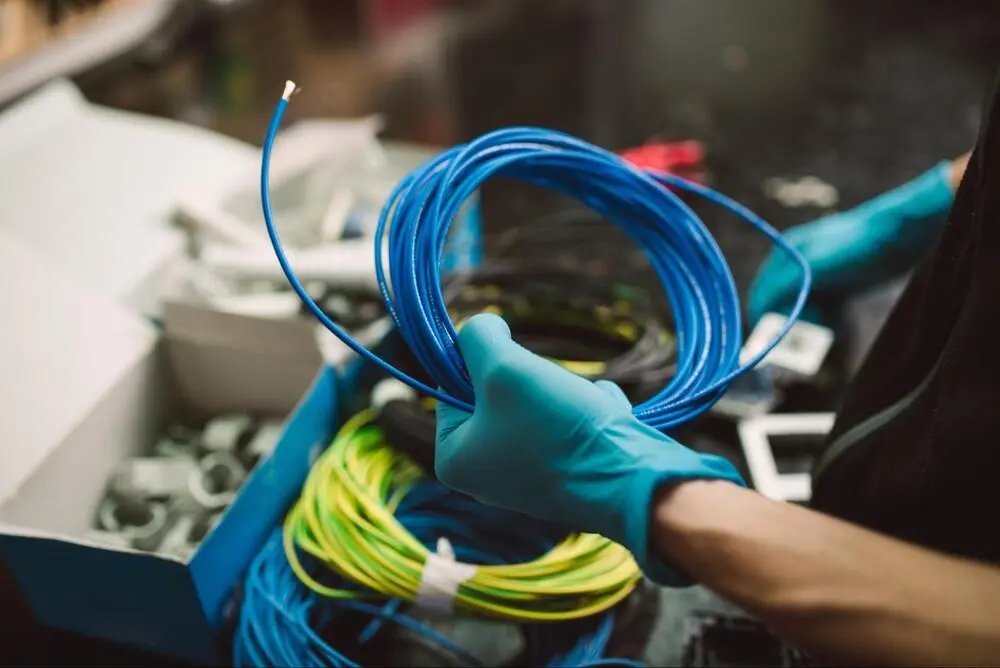 A technician holding blue cable for cable installation A technician holding blue cable for cable installation