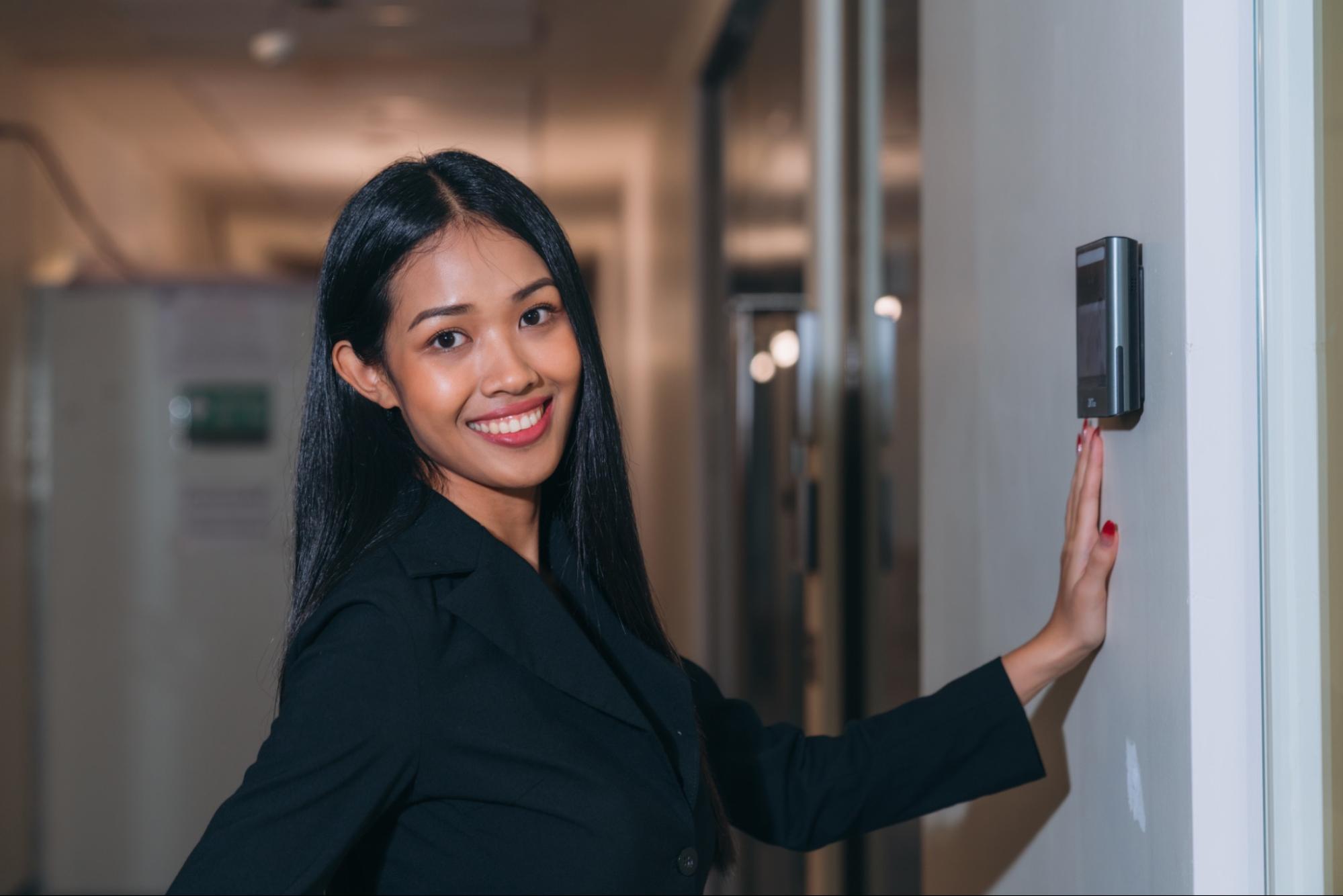 Professional Office Keycard Access System A professional woman tapping an access card on a wall-mounted reader to unlock an office door