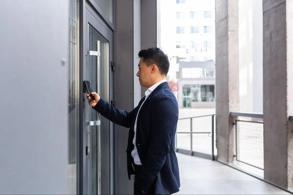 Access control system reader at commercial building entrance Businessman using a card reader to enter a building with an access control system